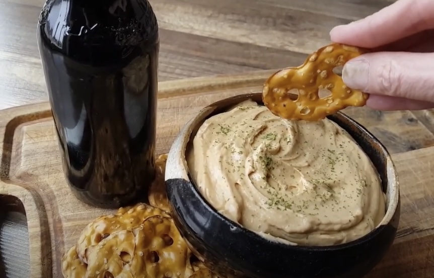 A pretzel dipped in pub cheese.
